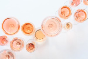 Many glasses of rose wine at wine tasting. Concept of rose wine and variety. White background. Top view, flat lay design. Natural light.